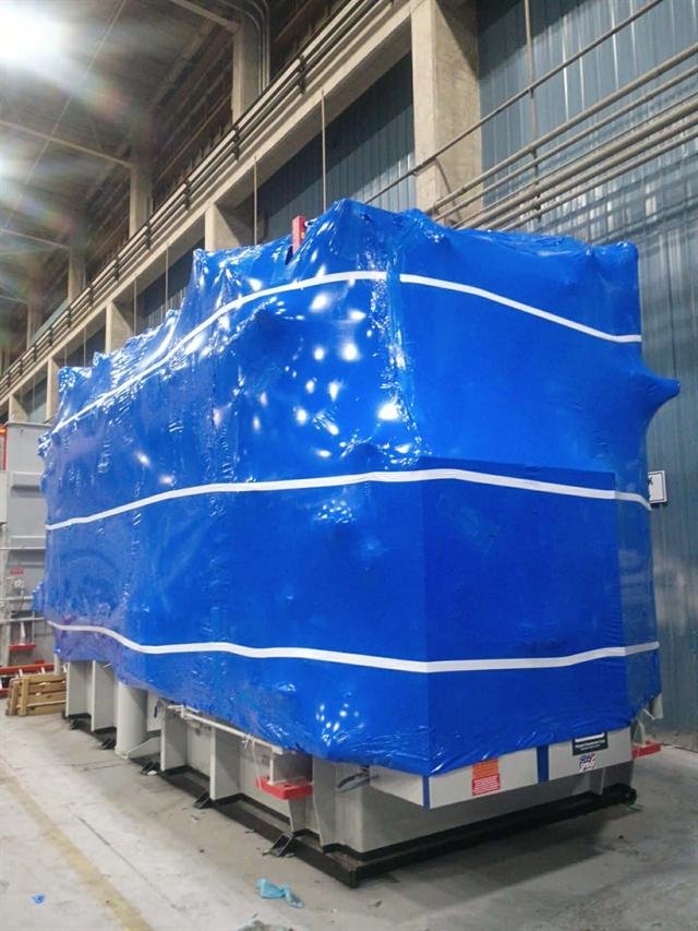 Large transformer drum-tight in blue shrink wrap, banded and ready for storage